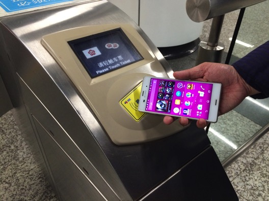 Using an NFC-equipped mobile phone at a turnstile of a metro station - simulated